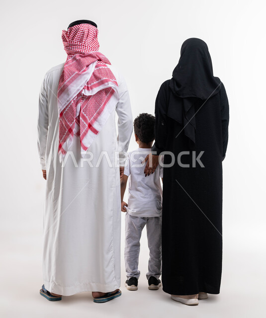 صورة الجسم بالطول الكامل، بناء مجتمع سعودي متنامي، قضاء الوقت مع الأهل والأبناء ،بورتريه من الخلف لعائله عربيه سعوديه خليجيه مكونه من الاب والام والابن، المحافظة على ترابط الاسرة، تربية الأولاد على المفاهيم الصحيحة، خلفية بيضاء