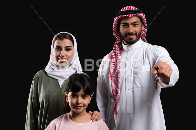 الأجواء العائلية المليئة بالحب، الإهتمام والإعتناء بالعائلة، بورتريه لرجل عربي سعودي خليجي مع عائلته يشير بأصبع السبابة نحو شيء ما، المحافظة على الترابط الأسري والإستقرار العائلي، إيماءات اللمس والضغط، حركة أصبع وإشارات، خلفية سوداء