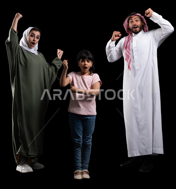 قضاء أوقات عائلية ممتعة ومليئة بالحب، بورتريه لعائلة عربية خليجية سعودية تقوم برفع يدها لأعلى والتشجيع بحماس وشغف، إيماءات السعادة بالفوز والإنتصار والكسب، الترابط الأسري والمحافظة على الأمان والإستقرار العائلي، صورة الجسم بالطول الكامل، خلفية سوداء