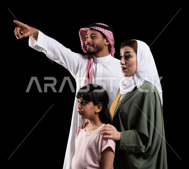 Mother and daughter gestures of astonishment, astonishment and astonishment, family bonding and maintaining the safety and stability of the family, a portrait of a Saudi Arabian Gulf man accompanied by his family, pointing with the index finger to draw at