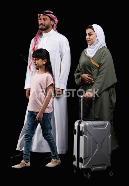 امرأة تقوم بجر حقيبة الأمتعة، الإستعداد لقضاء الإجازة الصيفية والذهاب في رحلة سفر ممتعة، بورتريه لعائلة عربية سعودية خليجية بإيماءات الحركة والمشي، المحافظة على أمان وإستقرار وترابط الأسرة، الأجواء العائلية المليئة بالحب، صورة الجسم بالطول الكامل، خلفية س
