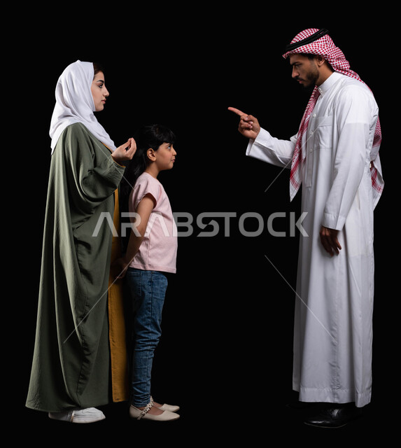 مفهوم التربية وتعديل سلوكيات الأبناء الخاطئة، بورتريه لعائلة عربية سعودية خليجية، إيماءات الغصب والحزن والخوف، أب يقوم بتوبيخ وتحذير إبنته من تكرار الأخطاء، طلب الزوجة من الزوج الصبر والتريث والهدوء، صورة الجسم بالطول الكامل، خلفية سوداء
