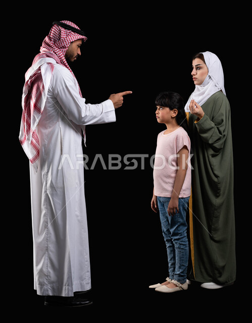 أب يقوم بتوبيخ وتحذير إبنته من تكرار الأخطاء، بورتريه لعائلة عربية سعودية خليجية، مفهوم التربية وتعديل سلوكيات الأبناء الخاطئة، إيماءات الغصب والحزن والخوف، طلب الزوجة من الزوج الصبر والتريث والهدوء، صورة الجسم بالطول الكامل، خلفية سوداء