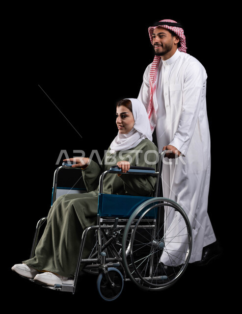 الإخلاص والعطف والحنان بين الأزواج، زوج عربي خليجي سعودي يرتدي الزي السعودي يقوم بمساعدة زوجته من ذوي الاحتياجات الخاصه، مفهوم العنايه ورعاية المرضى والمعاقين ، الاهتمام بالجانب النفسي والجسدي للمقعدين, شعور ذوي الهمم بالراحه في بيئتهم, خلفية سوداء
