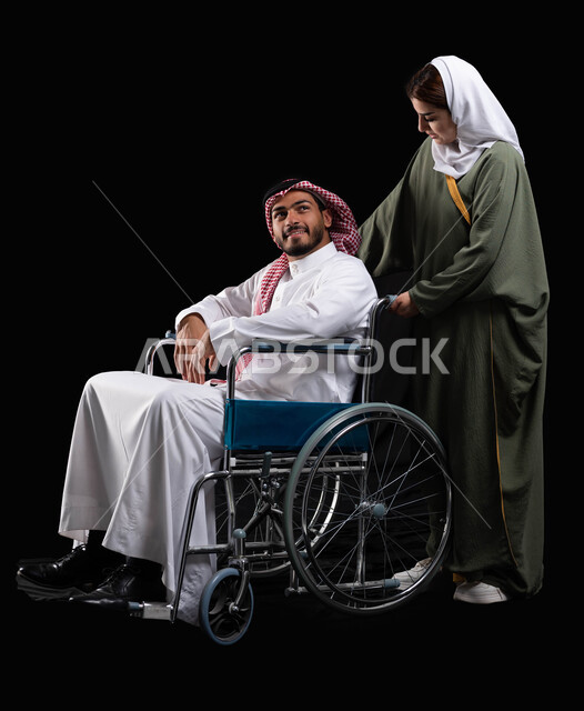  اهتمام ودعم المجتمع السعودي لاصحاب لهمم, شعور المعاقين بالإنتماء والتقدير والإحترام في السعوديه، زوجة عربية خليجية سعودية محجبة ترتدي العباءة تقوم بمساعدة زوجها من ذوي الاحتياجات الخاصه، قوة العزيمة والتحدي عند أصحاب الهمم, خلفية سوداء