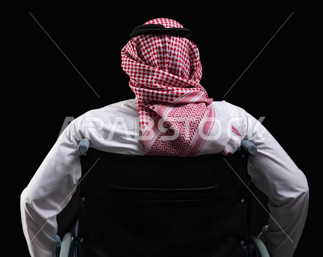 تحسين حياة ذوي الإعاقة الحركية, مريض يجلس على كرسي متحرك، تأمين اجهزة ومعدات تساعد بالحركة والتنقل، العنايه بأصحاب الهمم وتأمين احتياجاتهم الخاصة، صورة مقربة من الخلف لرجل عربي سعودي خليجي يرتدي الزي السعودي من ذوي الاحتياجات الخاصه، خلفيه سوداء