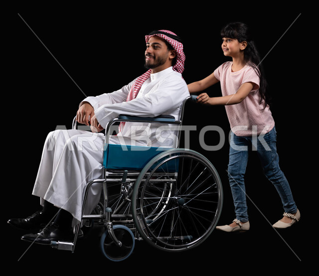 The concept of honoring parents and caring for people with special needs, a portrait of a Saudi Arabian Gulf father wearing the traditional dress accompanied by his daughter sitting in a wheelchair, the disabled feeling of appreciation and respect and sec