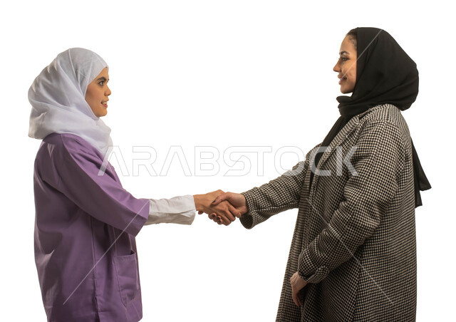 استئجار العماله المنزليه المرخصه والمؤهله، توفير خدمات العناية بالمنزل من حيث النظافة والترتيب، بورتريه مقرب لإمرأة عربية خليجي سعودية محجبة تصافح عاملة نظافة منزلية افريقية، الترحيب بالعاملات والخادمات من الشركات السعوديه، مهن ووظائف نسائية، خلفية بيضاء