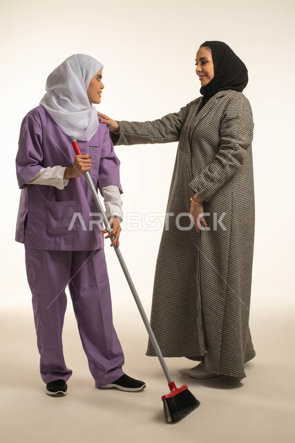  المعامله الحسنه للخادمات، توفير خدمات العناية بالمنزل والنظافة والترتيب، بورتريه لسيدة عربية خليجية سعودية تقوم بشكر العامله المنزليه على النظافه والإهتمام، خادمة افريقية تستخدم المكنسة اليدوية، استقدام العمالة الخارجية المرخصة والمؤهلة، خلفية بيضاء
