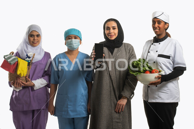 الخدمات الالكترونيه المتقدمه لدعم وتوفير الخادمات والممرضات والطباخات المدربه والمؤهله، منصات إلكترونية مؤهله لاستقدام العماله المنزليه، بورتريه لسيدة سعودية محجبة تحمل هاتف بشاشة سوداء فارغة بجانبها مجموعة من عاملات المنزل، مهن ووظائف نسائية، خلفية بيضاء