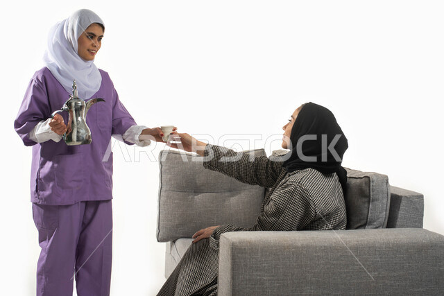 أداء الأعمال المنزلية الروتينية على أكمل وجه، بورتريه من الجانب لسيدة عربية خليجية سعودية محجبة تجلس على الأريكة وتأخد كوب القهوة من الخادمة الإفريقية، حسن الضيافة والاستقبال، الاستعانة بمساعدة عاملة فلبينية في المنزل، خلفية بيضاء