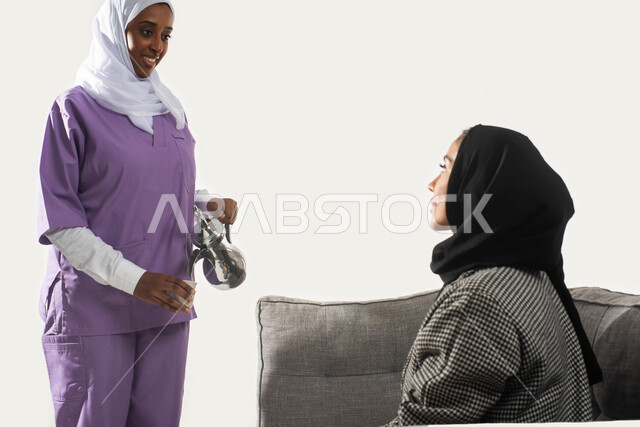 القيام بالمهام والأعمال المنزلية الروتينية، حوارات ونقاشات مدبرة المنزل مع خادمة منزلية أجنبية، بورتريه لخادمة فلبينية تقوم بصب القهوة لسيدة عربية خليجية سعودية محجبة، حسن الضيافة والاستقبال، خلفية بيضاء