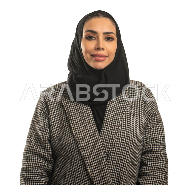 إيماءات وجه تدل على الثقة بالنفس، الاهتمام بالمظهر الخارجي، بورتريه مقرب لسيدة عربية خليجية سعودية محجبة ترتدي الزي السعودي التقليدي وتنظر إلى الكاميرا، خلفية بيضاء.