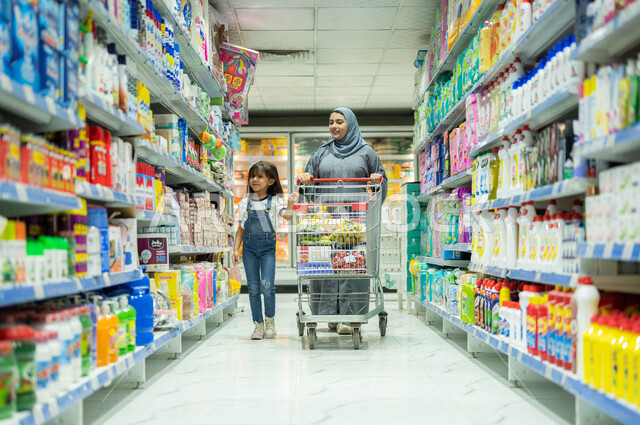 تعليم الأطفال على حب المساعدة والشعور بالمسؤولية منذ الصغر، إمرأة عربية خليجية سعودية ترتدي العباءة الرمادية والحجاب تقوم بالتبضع برفقة ابنتها، قضاء وقت ممتع في السوبرماركت، شراء بعض الحاجات والمستلزمات الضرورية، الاستفادة من العروض والخصومات على المنتجات