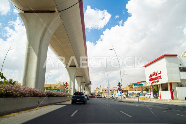 The train of the Riyadh metro line in the Kingdom of Saudi Arabia, the advanced, modern and fast means of transport and communications, the architectural engineering design of the roads and streets in Riyadh, the suspension bridge supported by cables in b
