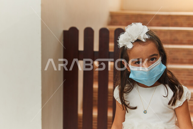 الإحتراز وتجنب العدوى بفايروس كورونا، صوره مقربه لفتاة عربية خليجية إماراتية تقوم بالنظر للكاميرا وتضع الكمامه للحماية من كوفيد-١٩، الإلتزام بالإجراءات والقوانين الوقائيه لوزاره الصحه.