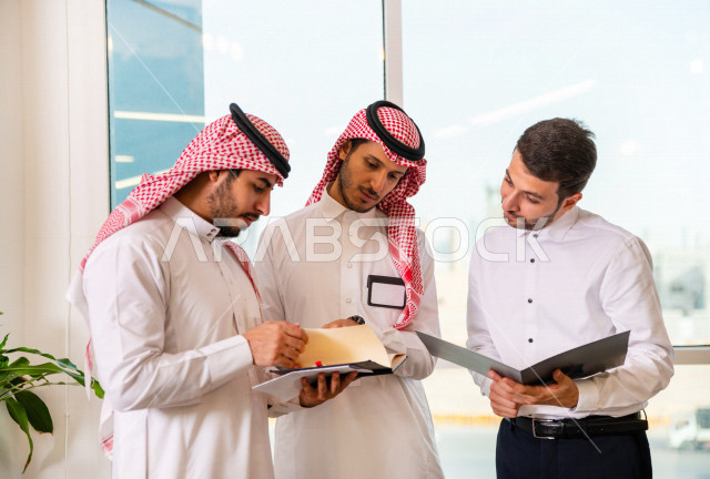 مجموعة من رجال الأعمال الرياديون الخليجيون ، احدهم من جنسية مختلفة يرتدي البدلة الرسمية ، ادارة الاعمال داخل مقر الشركة ، مناقشة اهداف وخطط المؤسسة، شركة سعودية ، بيئة العمل