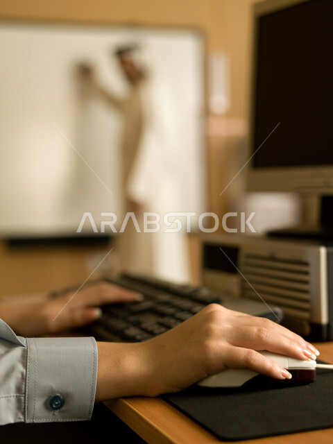 المدارس في الإمارات العربية، صورة ظلية لمعلم عربي خليجي إماراتي في مختبر الحاسب الآلي، تعليم الطلبة كيفية استخدام الكمبيوتر في المدرسة، صورة مقربة ليد طالبة تستخدام لوحة المفاتيح للكتابة، التعليم الالكتروني والمناهج المطورة، المشاركة الفعالة للطلاب.