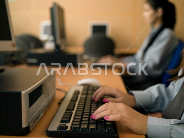 المدارس في الإمارات العربية المتحدة، تعليم الطلبة كيفية استخدام الكمبيوتر في المدرسة، صورة مقربة ليد طالبة عربية إماراتية خليجية تستخدم لوحة المفاتيح للكتابة في مختبر الحاسب، التعليم الالكتروني والمناهج المطورة، المشاركة الفعالة للطلاب.