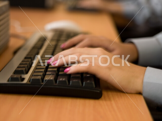 Schools in the United Arab Emirates, teaching students how to use a computer at school, a close-up of the hand of an Arab Emirati Gulf student using the keyboard to write in the computer lab, e-learning and developed curricula, active participation of stu
