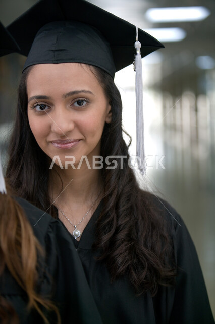 الابتهاج والسرور والاحتفال بيوم التخرج بإيماءات السعادة, الاحتفالات بتحقيق حلم النجاح من الجامعة, صورة مقربة لطالبة عربية خليجية إماراتية ترتدي زي التخرج والقبعة تحمل بيدها شهادة التفوق والنجاح, اللباس الأكاديمي الموحد لخرجي الجامعات والمعاهد الدوليه