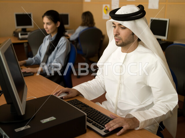 مدارس أكاديمية في الإمارات العربية، المناهج المطورة والتعليم الالكتروني، التطبيق العملي للطلاب، تعليم الطلبة كيفية استخدام تقنيات الكمبيوتر في المدرسة، طلاب عرب خليجيون إماراتيون يقومون بالعمل والتعلم في مختبر الحاسب.