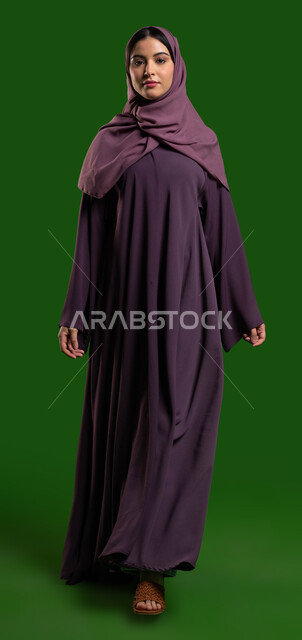 عبايات سعودية نسائية بتصاميم عصرية مميزة، بورتريه لسيدة عربية خليجية سعودية محجبة بإيماءات تدل على السعادة والسرور، المشي والتقدم للأمام يثقة، مفهوم الموضة والأناقة والجمال، خلفية كروما خضراء