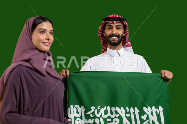 إحياء ذكرى إعادة توحيد الوطن، اليوم الوطني لتوحيد المملكة 8 ربيع الأول، بورتريه لمواطن ومواطنة عربيان خليجيان سعوديان بإيماءات السرور والسعادة، شاب سعودي يمسك علم السعودية بفخر واعتزاز، يوم العلم 11 مارس، العيد الوطني السعودي، كروما، خلفية خضراء