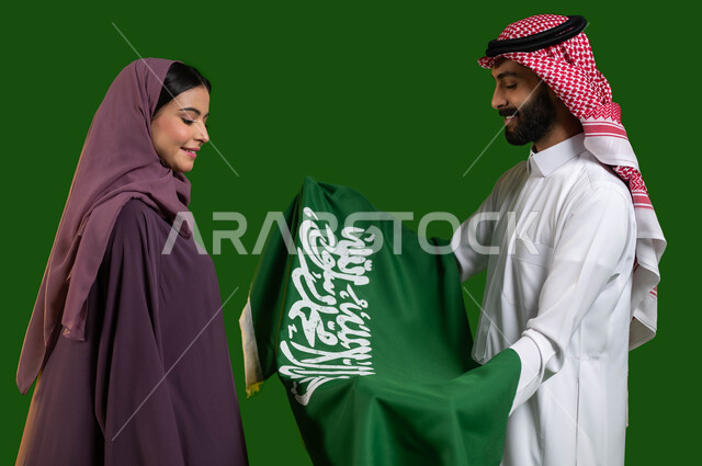 The concept of loyalty and loyalty to the Kingdom, looking at the Saudi flag with pride and pride, a portrait of a Saudi Arabian Gulf man and woman celebrating the National Day 8 Rabi` al-Awwal, the Saudi National Day, the Saudi Flag Day March 11, participation in national events and holidays, chrome, green background