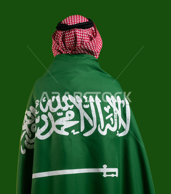 اليوم الوطني لتوحيد المملكة، المشاركة بالمناسبات و الأعياد الوطنية، بورتريه من الخلف لرجل عربي خليجي سعودي يرتدي علم السعودية على ظهره، الإحتفال بيوم العلم 11 مارس، العيد الوطني السعودي 8 ربيع الأول، حب الوطن والافتخار والاعتزاز به، كروما، خلفية خضراء