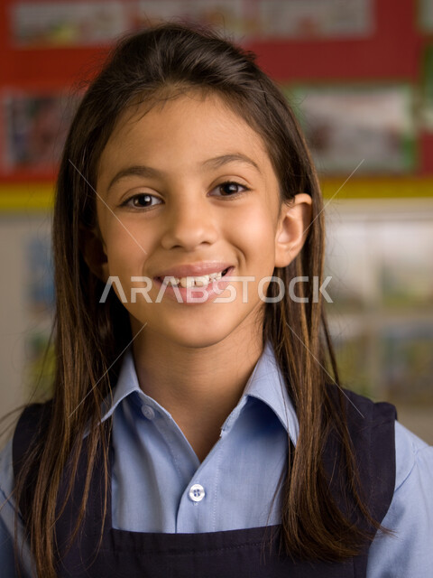 الاستعداد للعام الدراسي الجديد، التقاط صور شخصية للطلاب لتجهيز البطاقات التعريفية، صوره مقربة لفتاة عربية خليجية إماراتية ترتدي الزي المدرسي مبتسمة تنظر إلى الكاميرا، إيماءات وجه تدل السعادة بالعودة إلى المدرسة، المدارس الأكاديمية في الإمارات العربية.