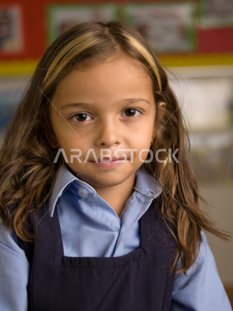 المدارس الأكاديمية في الإمارات العربية، الاستعداد للعام الدراسي الجديد، التقاط صور شخصية للطلاب لتجهيز البطاقات التعريفية، صوره مقربة لطالبة عربية خليجية إماراتية ترتدي الزي المدرسي تنظر إلى الكاميرا، فتاة هادئة مهذبة خلوقة.