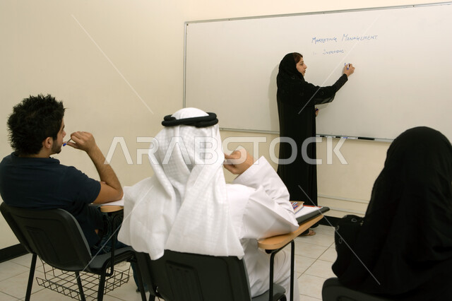 تدوين الملاحظات على السبورة البيضاء، الإنتباه والتركيز والإستماع إلى المحاضرة، أستاذة جامعية عربية خليجية إماراتية تقوم بشرح المحاضرة لطلابها، ورش عمل ودورات تدريبية في الإمارات، التعليم العالي في الجامعات والكليات الأكاديمية في الإمارات العربية المتحدة