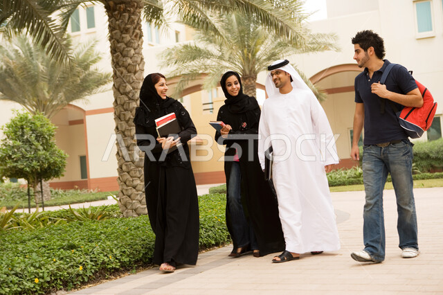 حوارات ونقاشات طلابية في الجامعة، تبادل الحديث أثناء وقت الإستراحة، طلاب جامعيون عرب خليجيون إماراتيون من الذكور والإنات يتجولون في الحرم الجامعي، إيماءات السرور والسعادة بالتعارف على الزملاء وبناء الصداقات الجديدة، الجامعات والكليات الإماراتية