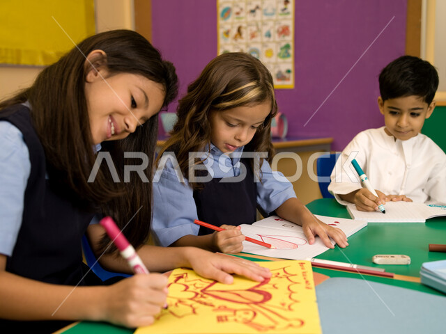 التعبير بالرسم عن الحب والمشاعر الإيجابية، مهارات وأنشطة فنية تساعد على تنمية القدرات العقلية والذهنية في مدارس الإمارات العربية، الاندماج والتركيز في الرسم والتلوين، تلاميذ عرب خليجيون إماراتيون يرتدون الزي المدرسي يقومون بالرسم والتلوين.