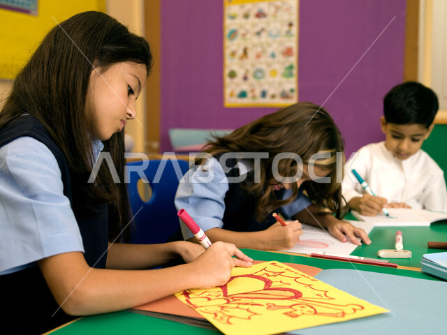 التعبير بالرسم عن الحب والمشاعر الإيجابية، مهارات وأنشطة فنية تساعد على تنمية القدرات العقلية والذهنية في مدارس الإمارات العربية، الاندماج والتركيز في الرسم والتلوين، تلاميذ عرب خليجيون إماراتيون يرتدون الزي المدرسي يقومون بالرسم والتلوين.