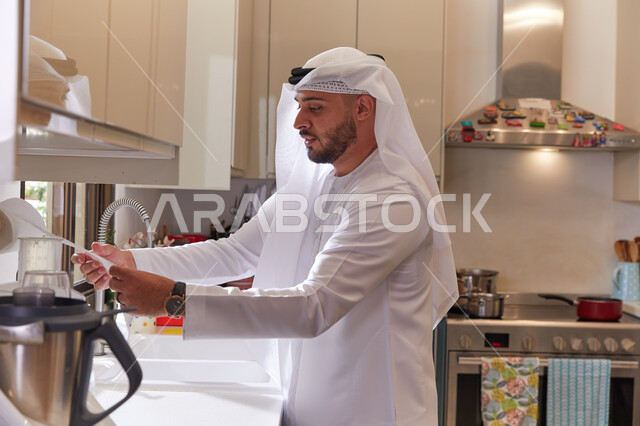 الإهتمام والعناية بالنظافة الشخصية، الالتزام بالتعليمات الوقائيه للحماية من الجراثيم والميكروبات، رجل عربي خليجي اماراتي يرتدي الغتره والكندوره بقوم بتجفيف يديه بالمناديل الورقية، اتباع اساليب الحرص وتجنب انتشار العدوى.