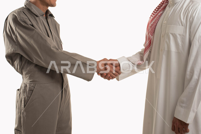 مهن ووظائف سعودية, الاتفاق على انجاز مهام العمل, بورتريه لرجل عربي خليجي سعودي يرتدي الثوب التقليدي والشماغ يصافح عامل صيانة, ارتداء زي العمل الخاص, التعارف وبناء العلاقات الاجتماعية, خلفية بيضاء
