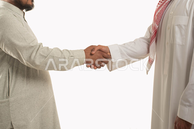 التحية والسلام والاتفاق على انجاز المهام, بورتريه مقرب لشاب عربي خليجي سعودي يرتدي الثوب والشماغ يصافح رجل سعودي, مهن ووظائف سعودية, الحرف اليدوية التقليدية, التعارف وبناء العلاقات الاجتماعية, خلفية بيضاء