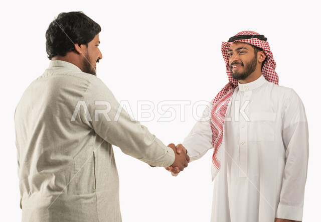 الحرف اليدوية التقليدية, التعارف وبناء العلاقات الاجتماعية, السلام والتحية والاتفاق على انجاز المهام, بورتريه مقرب لشاب عربي خليجي سعودي مبتسم يرتدي الثوب والشماغ يصافح رجل سعودي, مهن ووظائف سعودية, خلفية بيضاء