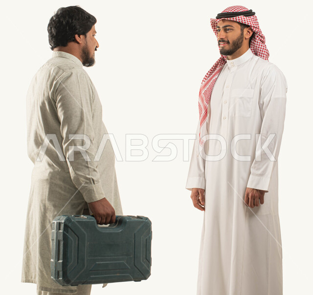 Traditional Saudi crafts and works, maintenance tools and equipment, portrait of a Saudi Gulf Arab man wearing the traditional dress and shemagh standing in front of the worker, a maintenance worker carrying a hand tool bag in his hands, Saudi professions and jobs, white background