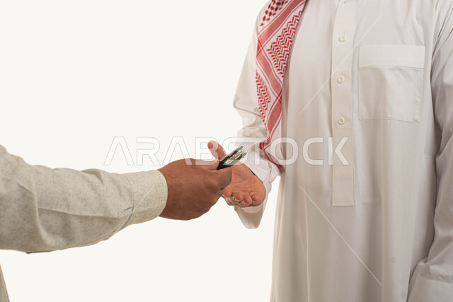 الحصول على خدمه صف السيارة, مفهوم القياده في السعودية, بورتريه لرجل عربي خليجي سعودي يرتدي الثوب التقليدي والشماغ يستلم مفتاح سيارته من السواق, خدمات الإصلاح والصيانه في الورشات, امتلاك سيارة جديدة, خلفية بيضاء