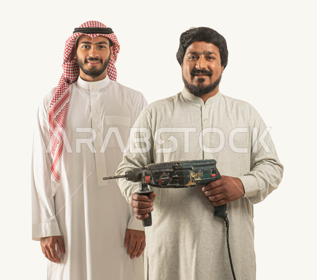 معدات الإصلاح والصيانة الكهربائية, انجاز مهام العمل, بورتريه لرجل عربي خليجي سعودي مبتسم يرتدي الثوب التقليدي والشماغ ينظر إلى الكاميرا, عامل صيانة يمسك مثقب كهربائي, أدوات الحفر والتثقيب, حرف ومهن يدوية, استقدام العمالة من الخارج, خلفية بيضاء
