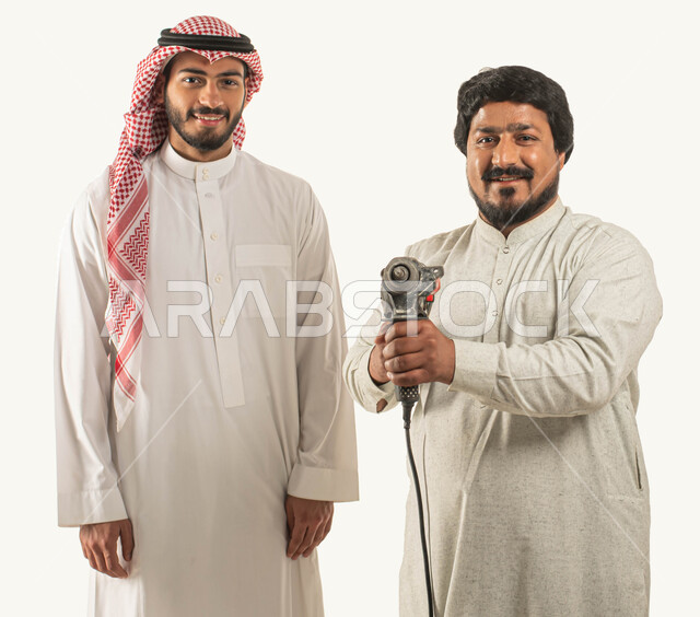 أدوات الإصلاح والصيانة الكهربائية, انجاز مهام العمل, بورتريه لرجل عربي خليجي سعودي مبتسم يرتدي الثوب التقليدي والشماغ ينظر إلى الكاميرا, عامل صيانة يمسك مثقب كهربائي, معدات الحفر والتثقيب, حرف ومهن يدوية, استقدام العمالة من الخارج, خلفية بيضاء