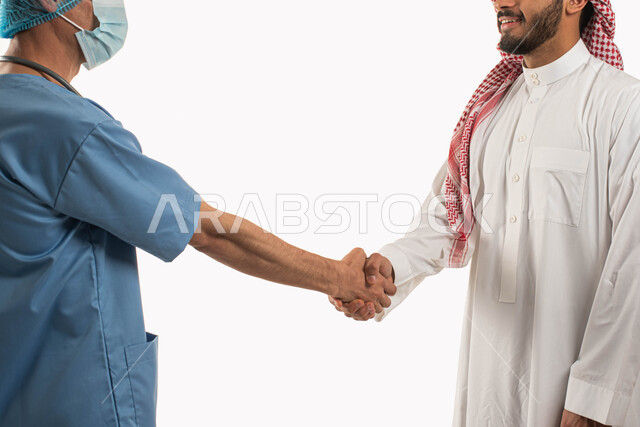 المصافحة والاستقبال برحابة صدر، الفحص الطبي والتشخيص السريع، بورتريه مقرب لرجل عربي سعودي خليجي يرتدي الزي التقليدي يقوم بزيارة الطبيب لإجراء الفحوصات الطبية الدورية، طبيب سعودي يرتدي الزي الخاص بالمهنة يعمل في المستشفيات والعيادات الخاصة، خلفية بيضاء