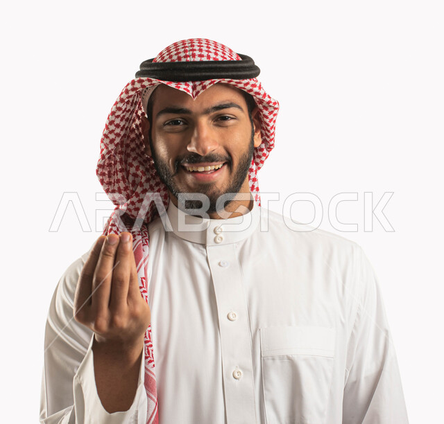 Giving time and waiting to do something, a portrait of a Saudi Arabian Gulf man wearing the traditional dress and shemagh and looking at the camera with pleasure and happiness, indicating patience, patience and hesitation, calmness and asking to stop, white background.