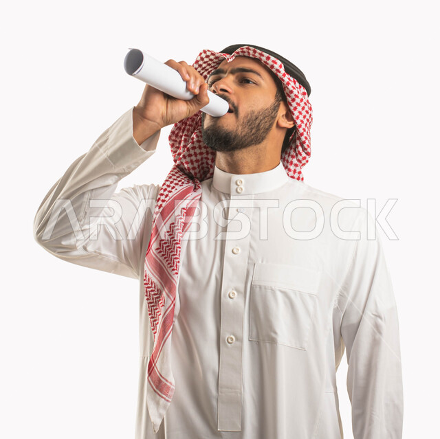 التدريب الصوتي وتقديم البرامج,  بورتريه لرجل عربي سعودي خليجي يرتدي الثوب و الشماغ التقليدي يتحدث من خلال ورقة بيضاء ملفوفة, فن إلقاء الخطابات و الندوات, إيماءات و تعابير وجه تدل على الاستمتاع, خلفية بيضاء .