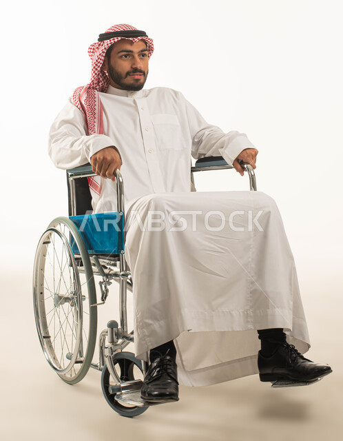 مريض مقعد يجلس على كرسي متحرك, تحسين حياة أصحاب الهمم وتأمين احتياجاتهم الخاصة, ايماءات التفاؤل بالمستقبل,  تأمين أجهزة ومعدات تساعد على الحركة, بورتريه مقرب لرجل عربي سعودي خليجي يرتدي الشماغ والثوب التقليدي متفائل بالحياة المستقبلية, خلفية بيضاء