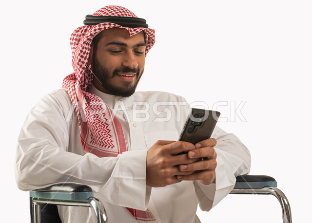 التواصل مع الأصدقاء، بورتريه لرجل عربي سعودي خليجي  يرتدي الشماغ والثوب التقليدي يقوم بعرض تطبيقات وبرامج ذوي الاحتياجات الخاصه,  تصفح الإنترنت،  إستخدام وسائل التواصل الإجتماعي، تسهيل حياة ذوي الهمم باستخدام التقنيه والتكنولوجيا، خلفية بيضاء