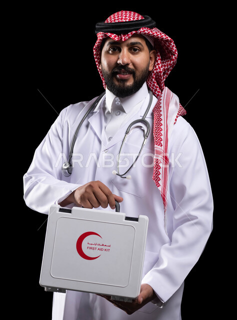 العمل في المراكز الصحية والمستشفيات ،الأدوات والمعدات الطبية اللازمة، مبادئ التعامل مع حالات الطوارئ، تقديم الخدمات العلاجية الطارئة للمرضى ، بورتريه لطبيب عربي سعودي خليجي يرتدي الثوب التقليدي و المعطف الطبي يحمل بيده حقيبة الاسعافات الأولية، خلفية سوداء